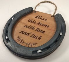 a horseshoe with a wooden sign that says, bliss this home with love and luck