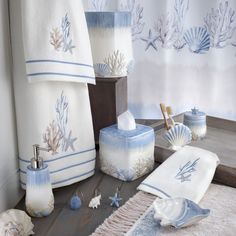 the bathroom is decorated in blue and white with shells, seashells and towels