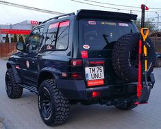 a black jeep parked on top of a brick road