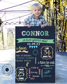 a young boy is holding up a chalkboard sign that says, connor as two years old