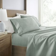 a bed with green and white striped sheets