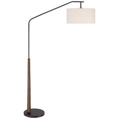 a floor lamp with a white shade on the top and a wooden pole underneath it