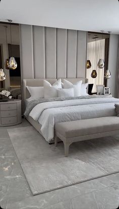 a large white bed sitting in a bedroom next to a tall mirror on the wall