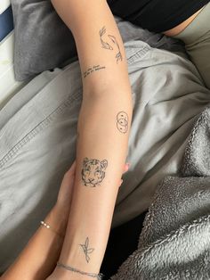 two people with tattoos on their arms and legs, one is holding the other's arm