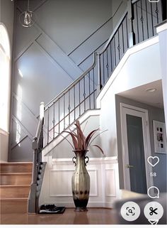 a vase sitting on top of a wooden floor next to a stair case in a house