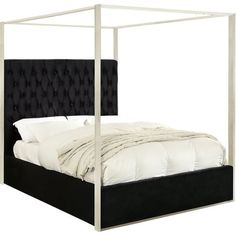 a bed with a black headboard and white sheets on it's sides,