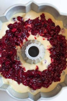 a cake pan filled with cream and cranberries