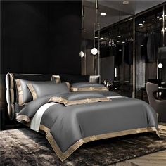 a bedroom with black walls and gold trimmings on the comforter, bedding and pillows