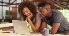 a man and woman looking at a laptop