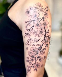 a woman with a tattoo on her arm that has flowers and the word love written in cursive writing