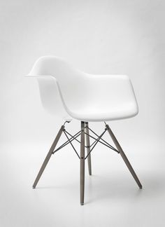 a white chair with wooden legs on a white background