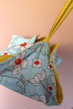 an origami flowered pouch with two yellow straws sticking out of it