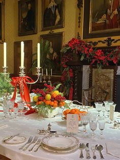 the table is set with oranges and silverware for an elegant christmas dinner party