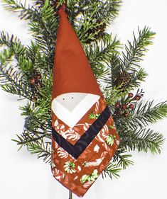 an ornament is hanging from a christmas tree with pine branches and cones on it