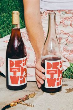 two bottles of wine sitting on top of a table next to a pair of scissors