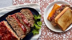 two slices of meatloaf on a plate next to another piece of bread with ketchup