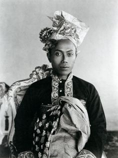 an old black and white photo of a woman with a headdress on her head