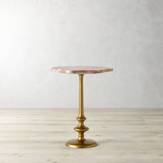 a gold pedestal with a pink marble top