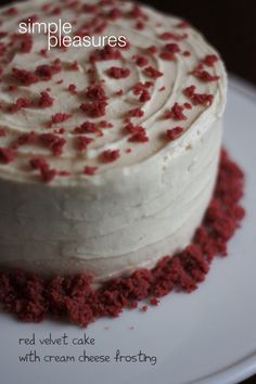 a red velvet cake with cream cheese frosting is shown on a white platter