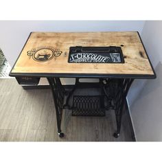 a wooden table topped with a black sewing machine