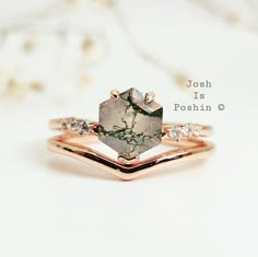 a close up of a ring on a white surface with flowers in the back ground