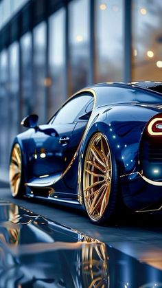 a blue bugatti with gold rims parked in front of a tall building