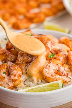 a wooden spoon in a bowl filled with shrimp and rice