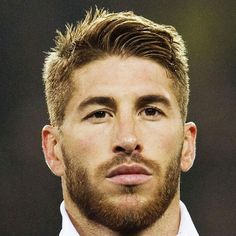 a close up of a man wearing a white shirt and tie with a goatee