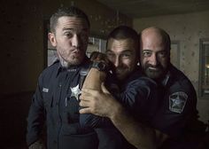 three men in police uniforms posing for the camera