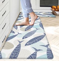 a person standing on top of a rug in a kitchen