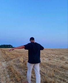 a man standing in a field with his arms outstretched