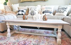 a living room filled with furniture and pillows on top of a rug in front of a couch