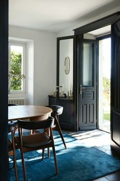 a dining room table and chairs in front of a door