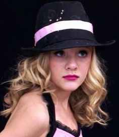 a woman with blonde hair wearing a black hat