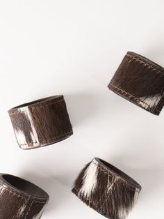 four brown and white fur lampshades sitting on top of each other