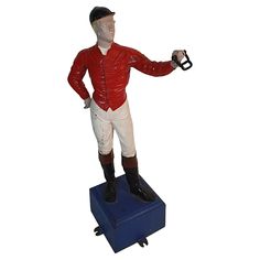 a figurine of a jockey holding a horse shoe on top of a blue box