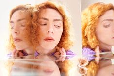 a woman with red hair is looking at herself in the mirror