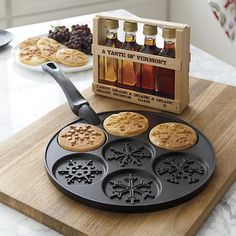 a wooden cutting board topped with cookies next to an assortment of syrups and bottles