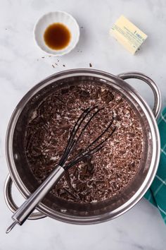 chocolate cake batter in a pan with whisk and butter on the side next to it