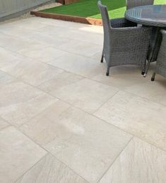 a patio with chairs, table and artificial grass