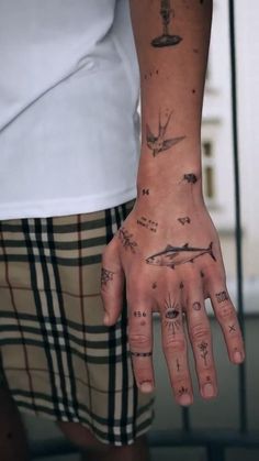 a person's hand with tattoos on it