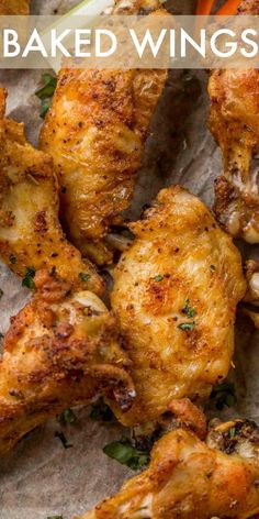 baked wings on parchment paper with carrots and celery