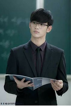 a man in a suit and tie holding a book