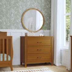 a baby's room with two wooden cribs and a mirror on the wall