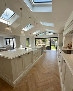 an open kitchen and living room with skylights