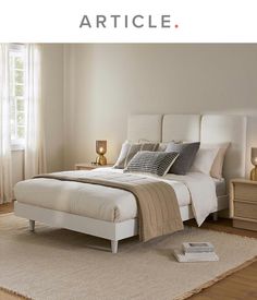 a bed sitting in a bedroom on top of a wooden floor next to a window