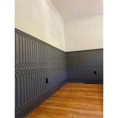 an empty room with wood floors and gray wall paneling on the walls is pictured in this image