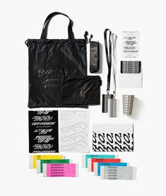 the contents of a black tote bag laid out on top of each other,