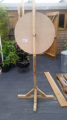 a large wooden object on top of a wooden stand next to other wood planks