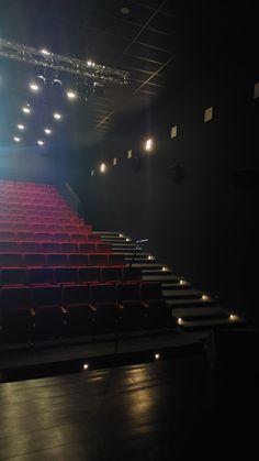 an empty auditorium with red seats and lights